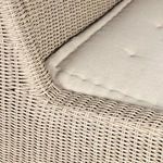 Macro view of rattan weave and fabric cushion junction with tight stitching