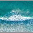 Aerial view of vibrant turquoise ocean with white-capped waves rolling and foaming in dynamic motion