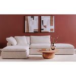 Front view in living room with light beige sectional sofa and red walls with abstract art behind the table