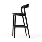 Multiple black bar stools paired with a dark wooden bar table in a minimalist setting