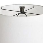 Close-up inside top of fabric shade showing black metal crossbar frame and textured finial