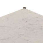 Close-up of sharp corner of marble top against rounded antique brass iron post