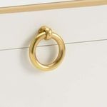 Close-up of antique gold round metal handle on cream wooden box