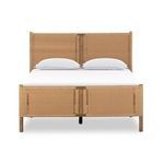 Close-up detail of woven rattan headboard panel edge and wood frame integration