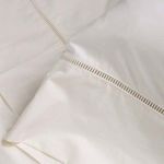 Close-up of ladder stitch embroidery detail on ivory cotton sateen fabric