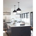 Two Montreux Pendants hanging over a kitchen island with dark cabinetry and stainless steel appliances