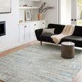 Rug styled in a modern living room with black sofa, concrete coffee table, wood floors, and natural light