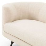Close-up of sofa’s seat and armrest showing woven fabric with fine texture and soft padding