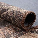 Rolled edge of rug showing thickness, texture, and stitched brown binding
