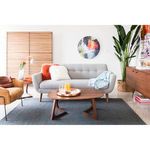 Godenza small coffee table in front of gray sofa with plush pillows, light wood floor and decorative modern art