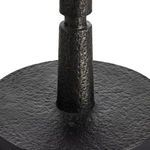 Close-up connecting textured black iron base cylinder to round base surface