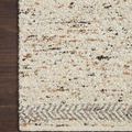 Close-up of rug corner on dark wood floor highlighting hand-knotted weave and multicolored yarn texture