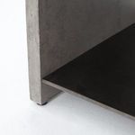 Close-up showing black metal shelf edge under solid concrete frame corner