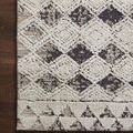 Close-up of Yeshaia rug corner showing woven texture and intricacies of black and neutral diamond pattern