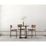 Three Sailor Stools arranged around a round wooden table on textured rug in bright room