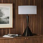 Clement table lamp styled on wooden cabinet against vertical wood panel wall with framed artwork