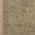Close-up top-down view highlighting the rug’s muted floral motifs and edge stitching on a wood floor background