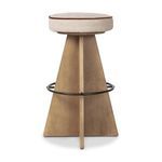 Damon swivel stool with a geometric wooden base, circular metal footrest, and round beige upholstered seat with brown piping