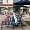 Row of Provence Chaise Lounges with navy and white cushions, orange folded towels, and navy umbrellas at poolside