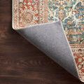 Rug corner flipped to show muted gray backing fabric and finished edge stitching