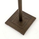 Top-down close-up of square base showing textured antique brass finish and pedestal connection