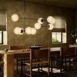 Side room view of chandelier illuminating dining area with wood furniture and soft natural window light