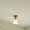 Illuminated Boston Single Flush Mount with warm light glowing in a room with white paneled walls and window trim