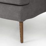 Close view of tapered solid oak leg with visible wood grain under seat upholstery
