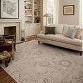 Louisa oatmeal rug styled in bright living room with cream sofa, wooden floors, and built-in shelves