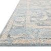 Low-angle side view showing thin profile and detailed edge binding of sky beige rug