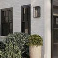 Matte black Royster Outdoor Wall Sconce with unlit bulb in front view on white background