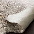 Underside of Bryce rug folded to reveal smooth light beige backing texture