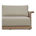 Close-up side view focusing on the curved wicker armrest and plush beige seat cushions