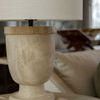 Table lamp positioned on side table with white sofa and decorative items in soft-focus background