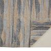 Back corner of Beckett rug folded to show weave and backside weave pattern with fringe visible