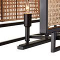 Close-up detail of candle-style bulb and black metal stand against woven rattan panels