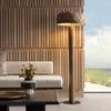 Room corner showing lamp lighting ribbed wood wall with view through window to a cloudy sky outside