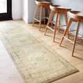 Runner version of Rosette Sand Ivory rug under wooden bar stools on light hardwood floor
