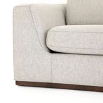 Detailed close-up of flared armrest meeting seat cushion and wood base