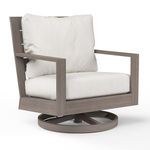 Laguna Swivel Club Rocker with driftwood-finish aluminum frame and plush off-white cushions