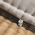 Close-up showing fabric cushion button tuft and beige textured upholstery