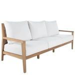 Three-quarter angled view of sofa with white cushions and teak frame