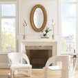 Lucius Mirror displayed above a mantel in a bright room with two white modern chairs and tall windows