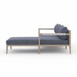 Side profile of sectional showing low back and armrests wrapped with woven detailing
