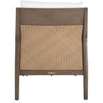 Outdoor porch scene with lounge chair featuring raffia back and white cushions, side table and decor