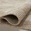 Corner of rug rolled over showcasing tight weave and material texture of polypropylene fibers