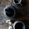 Top view of Valley Nature Bowl used as mortar with pestle, alongside smaller bowls and garlic on stone surface