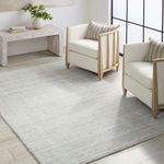 Rug in a room with natural light showcasing scale next to furniture and wood flooring