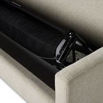 Partial side view of sleeper mechanism emerging from sofa base with folded mattress inside