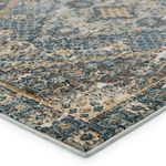 Close-up of rug corner showing woven texture and edge binding in blue and gold hues